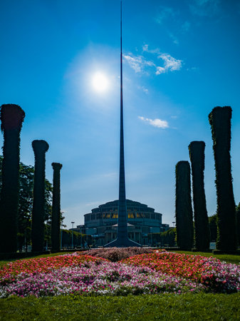 Wroclaw, Poland - August 2021: Iglica tower with flowers in front of standing in front of Centennial Hall buildingの写真素材