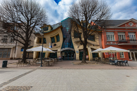 Sopot, Poland - April 2022: "Krzywy Domek" unusual commercial building with a curved structure housing shops, restaurants and cafes with outdoor seatingのeditorial素材