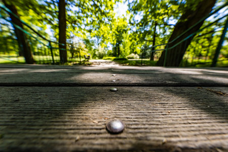Old renovated retro bridge with green metal railings over small river in small colorful park at sunny morningの写真素材