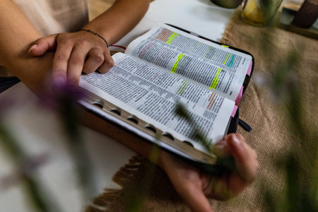 Reading Holy Bible with colorful highlights on pages which is lie on wooden tableの写真素材