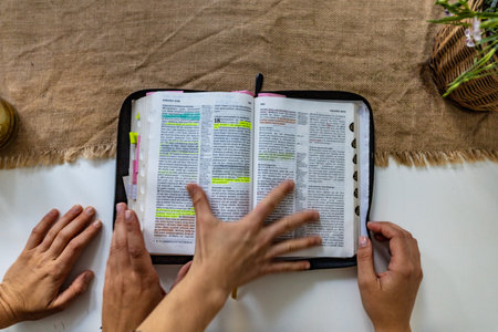 Reading Holy Bible with colorful highlights on pages which is lie on wooden tableの写真素材