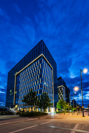 Warsaw, Poland - July 2022: Illuminated, tall office buildings standing next to the Warszawa Zachodnia station, seen at night during the blue hourのeditorial素材
