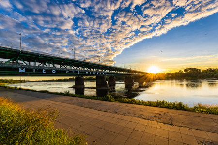Warsaw, Poland - July 2022: The green Gdansk bridge with the inscription "Milo Cie Dobrze" seen from the promenade at sunriseのeditorial素材