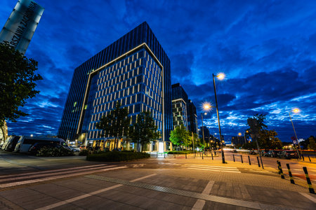 Warsaw, Poland - July 2022: Illuminated, tall office buildings standing next to the Warszawa Zachodnia station, seen at night during the blue hourのeditorial素材