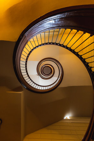 Spiral staircase with old wooden railings seen from below