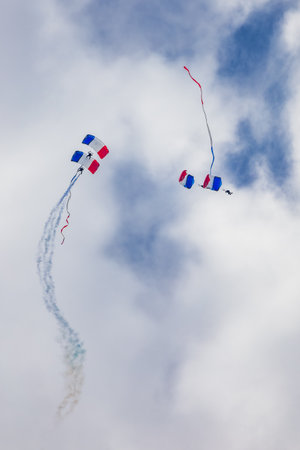 Leszno, Poland - June 16 2023: Antidotum Airshow Leszno 2023 and show of PHENIX Ambassadeurs Parachutistes flying down on parachutes with french and polish flag and a lot of smokeのeditorial素材