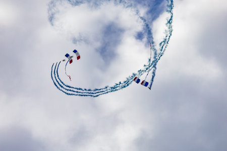Leszno, Poland - June 16 2023: Antidotum Airshow Leszno 2023 and show of PHENIX Ambassadeurs Parachutistes flying down on parachutes with french and polish flag and a lot of smokeのeditorial素材