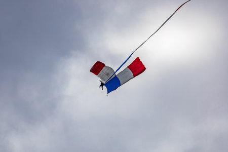 Leszno, Poland - June 16 2023: Antidotum Airshow Leszno 2023 and show of PHENIX Ambassadeurs Parachutistes flying down on parachutes with french and polish flag and a lot of smokeのeditorial素材