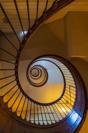Wroclaw, Poland - June 1 2023: Beautiful renovated old wooden spiral staircase inside old and high...