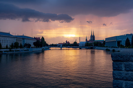 Wroclaw, Poland - July 13 2023: Beautiful and colorful sunset over Odra river with upcoming rainfall from west seen from Grunwaldzki bridgeのeditorial素材