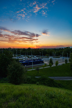 Wroclaw, Poland - August 23 2023: Beautiful cloudy sunset seen from Oporowskie hill over square with big tram depot with car parkingのeditorial素材