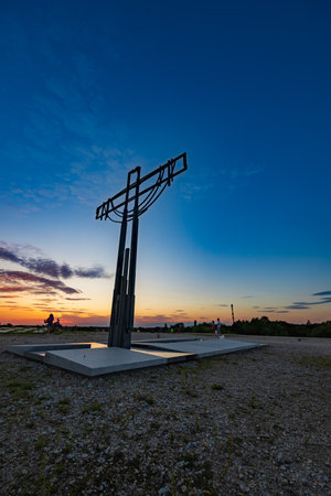 Wroclaw, Poland - August 23 2023: Beautiful big cross on top of Oporowskie hill with graves around at beautiful cloudy sunsetのeditorial素材
