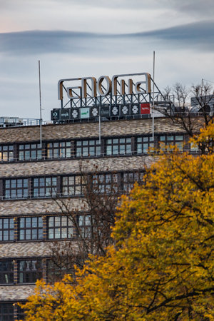 Wroclaw, Poland - November 12 2023: Beautiful facade of oldest shopping mall in Wroclaw city "Renoma" with big logo on top and seen from behind autumn trees and bridges with walking peopleのeditorial素材