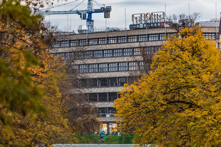Wroclaw, Poland - November 12 2023: Beautiful facade of oldest shopping mall in Wroclaw city "Renoma" with big logo on top and seen from behind autumn trees and bridges with walking peopleのeditorial素材