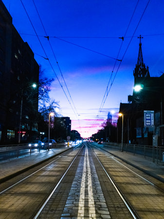 Wroclaw, Poland - December 17 2023: Beautiful and colorful cloudy afternoon at blue hour right after sunset over long Grabiszynska street in city centerのeditorial素材