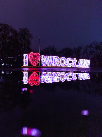Wroclaw, Poland - December 14 2023: Beautiful and colorfully glowing sign I Love Wroclaw standing at christmas time at freedom square in city center and reflecting in small puddleのeditorial素材