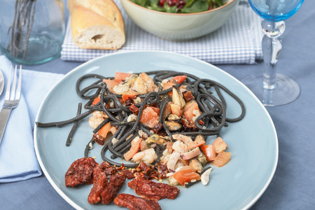 Spaghetti with squid ink with seafood and tomatoesの写真素材