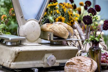 Crispy wholemeal bread loaves on a nostalgic scale at a weekly marketの写真素材