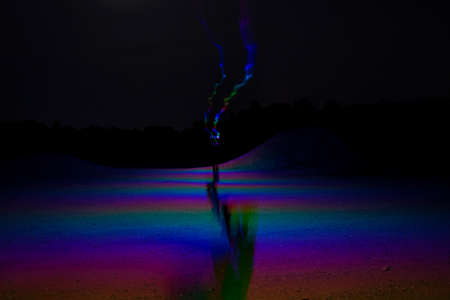 Long Exposure Night Photography,Man walking away holding lightの写真素材