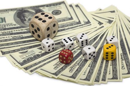 100 dollar false bills laid as semicircle and various dices on them