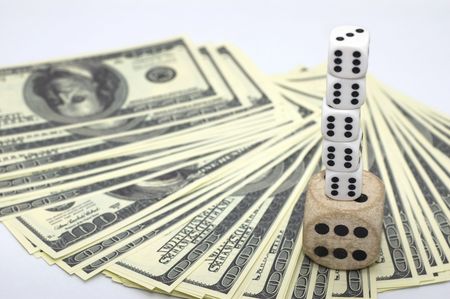 100 dollar false bills laid as semicircle and dices' pyramid standing on them
