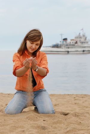 girl sitting on her knees at beach の写真素材