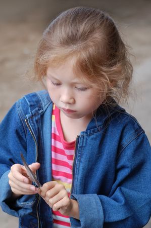 girl playing with birds feather with concentrationの写真素材