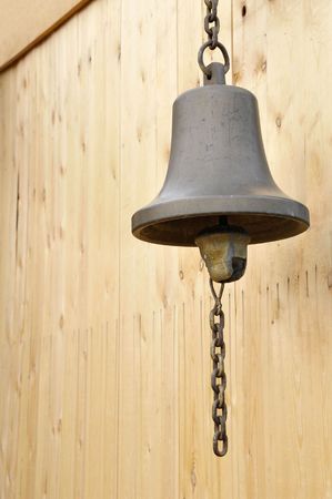 bronze bell with chain at wooden wallの写真素材