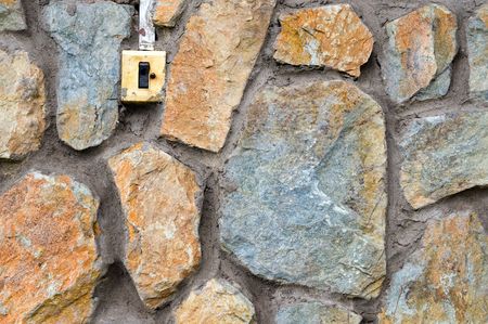 old fashioned electric switch in stone masonryの写真素材