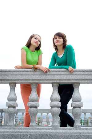 young beautiful european girls lean on banister with dreamy lookの写真素材
