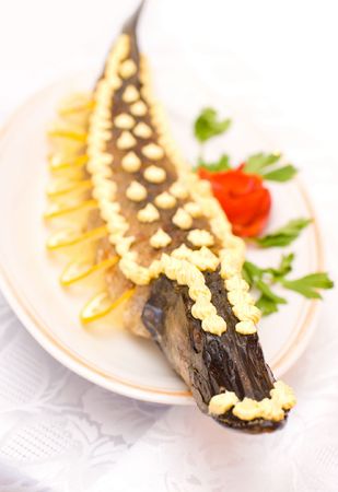 stuffed pike decorated with slices of lemon and butter creamの写真素材