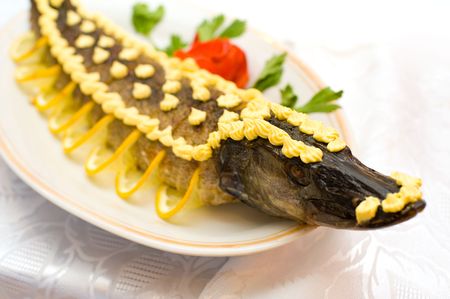 stuffed pike decorated with slices of lemon and butter creamの写真素材