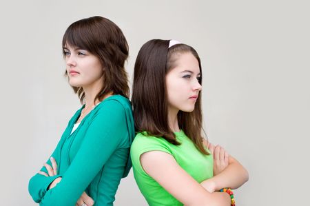 two young beautiful european girls stand back to backの写真素材