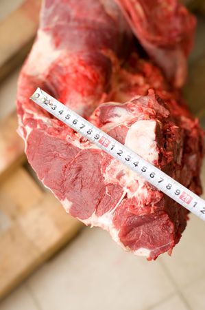 tape measure over piece of fresh beef の写真素材