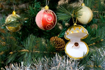 fragment of christmas tree with balls and gold ruby ring in jewel boxの写真素材