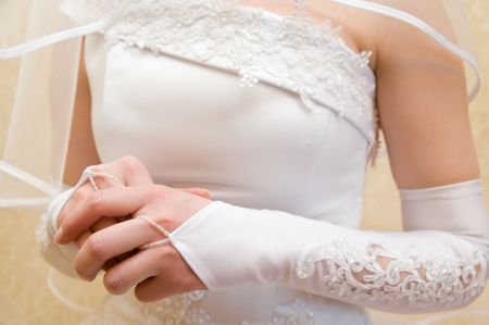 closeup shot of clasping hands of a bride who is nervous before courtship displayの写真素材