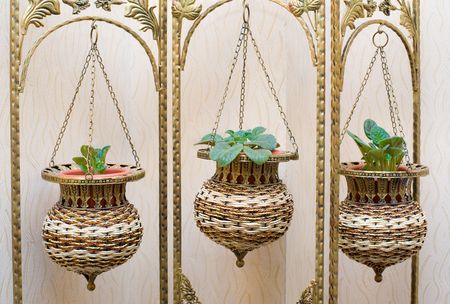pot flower stand, forged frame with wicker ornamental flowerpots on chainsの写真素材