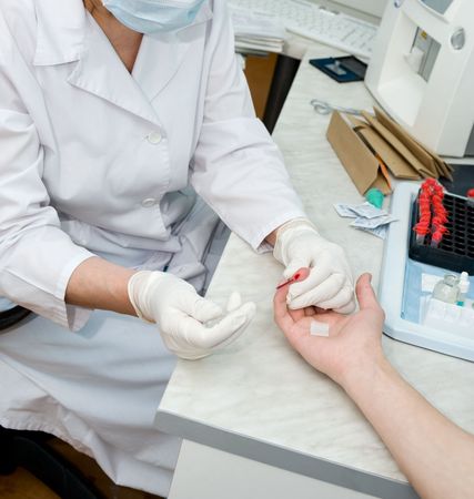 nurse collects blood specimen from a fingerの写真素材