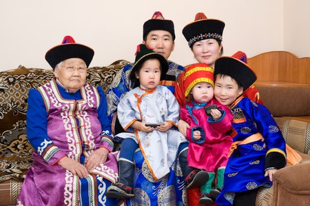 big buryat (mongolian) family: grandmother, grandson with wife and children, in national costumesの写真素材