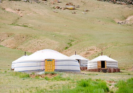 some Mongolian jurts camping at the mountain foot