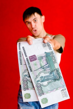 young man offers enlarged false ruble billsの写真素材