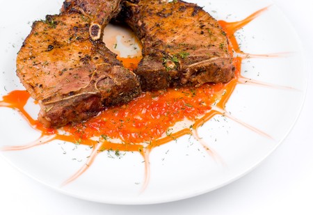 grilled steaks with tomato sauce on white plateの写真素材