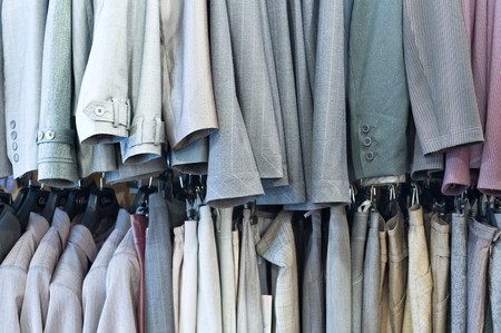 line of mens and ladies clothes hanging in shop