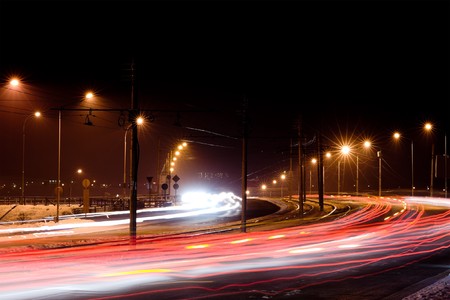 night city traffic lights in motion under street lampsの写真素材