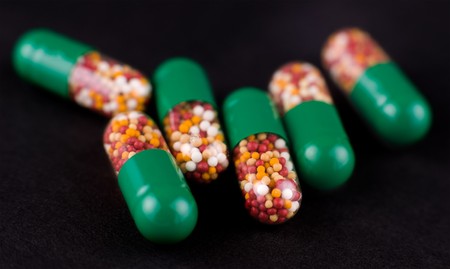 a macro shot of medicines, green capsulesの写真素材
