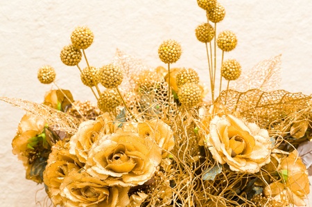 bouquet of golden artificial flowers and laced leavesの写真素材