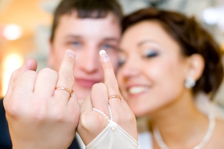 young happy newlyweds show their rings to cameraの写真素材