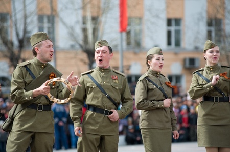 ULAN-UDE, RUSSIA - MAY 9: A group of actors wearing vintage (WWII's period) uniforms perform at the main city squre on annual Victory Day, May, 9, 2009 in Ulan-Ude, Buryatia, Russia.のeditorial素材