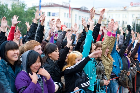 ULAN-UDE, RUSSIA - SEPTEMBER 5: Young viewers wave their hands cheerfully watching a festive show on the City Day celebration, September 5, 2009 in Ulan-Ude, Buryatia, Russia.のeditorial素材