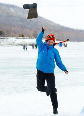 YARTSI, RUSSIA - APRIL 14  At annual Baikal Fishing Valenok Throwing was run, Apr 14, 2012, Yartsi, Buryatia, Russia  Sergei Klimov, president of Baikal Extreme Federation, makes an impressive try のeditorial素材